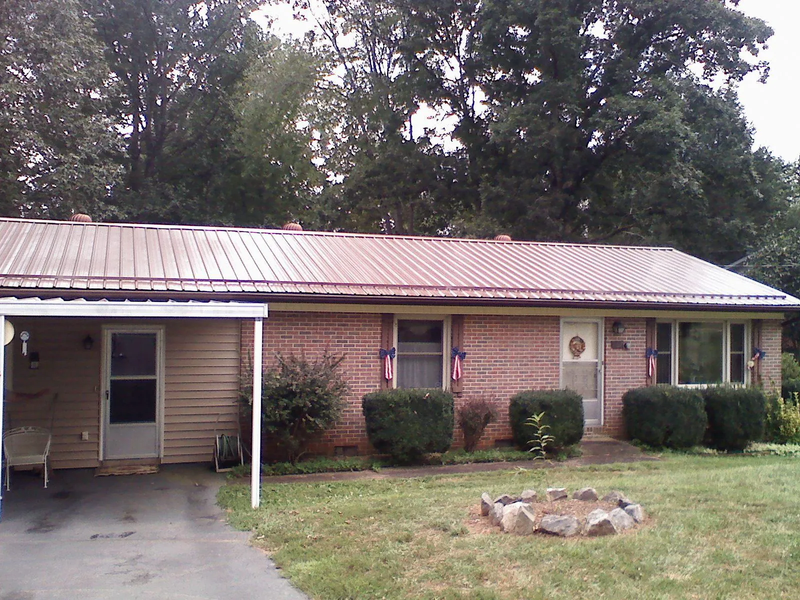 Bronze metal roof and carport on a brick ranch home — Roof Repair work by our crew in Albin